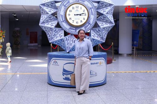 Chị Nguyễn Thị Tình (tỉnh Lai Châu) lần đầu đến ga metro Bến Thành và lưu lại hình ảnh bên các tác phẩm nghệ thuật công cộng.