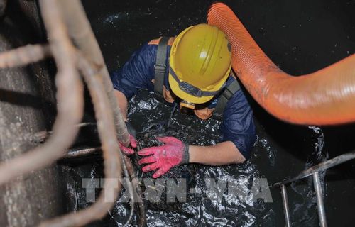 Trực tiếp ngâm mình dưới dòng nước cống đen ngòm để khơi thông dòng chảy, đảm bảo cuộc sống bình yên cho người dân Thủ đô. Ảnh: Phan Phương – TTXVN