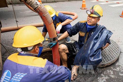 Kết thúc một ca làm thu gom rác dưới cống ngầm của các công nhân Công ty TNHH MTV Thoát nước Hà Nội. Ảnh: Tiến Long/TTXVN phát