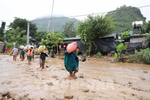 Các lực lượng chức năng hộ trợ giúp dân di chuyển tài sản đến nơi an toàn. Ảnh: Quý Trung - TTXVN