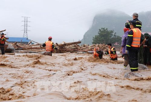 Lực lượng Công an tỉnh Lai Châu hỗ trợ cứu người bị cô lập về nơi an toàn. Ảnh: Quý Trung - TTXVN 