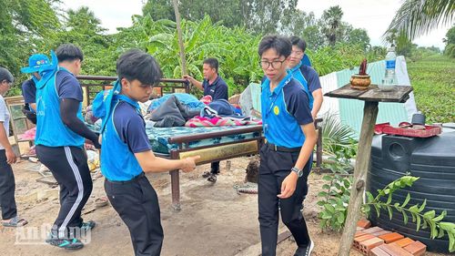 Đội sinh viên tình nguyện Trường Đại học An Giang giúp người dân dọn nhà hư hại sau đợt mưa lớn tại xã Núi Cấm. Ảnh: TIỂU ĐIỀN