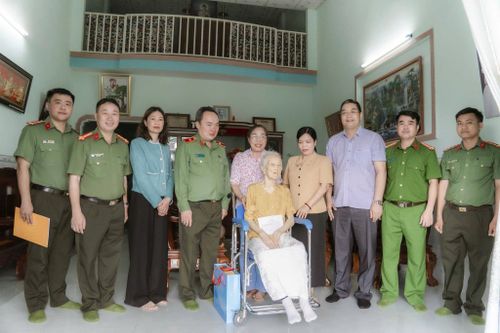 Đồng chí giám đốc công an tỉnh chụp hình lưu niệm cùng gia đình mẹ Việt Nam anh hùng Bùi Thị Xê. Ảnh: Lê Tiến