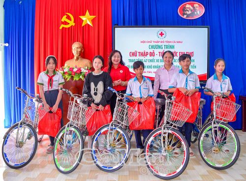 Phó Chủ tịch Hội Chữ thập đỏ tỉnh Hồ Quý Nhi và Phó Bí thư Thường trực Đảng ủy xã Tân Tiến Nguyễn Hải Âu trao xe đạp và quà cho học sinh.