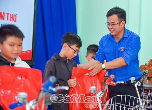 Anh Nguyễn Minh Thái, Bí thư Xã đoàn Tân Tiến, trao quà cho các em.