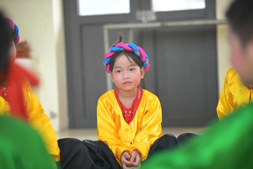Em nhỏ chăm chú lắng nghe những lời truyền đạt của các nghệ nhân.