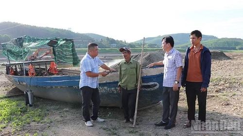Chủ tịch Ủy ban nhân dân xã Đức Phú, đồng chí Ngô Đức An (bên phải người cầm cuốc) tìm hiểu tâm tư của người dân sinh sống bên con sông Thuốc Hột.