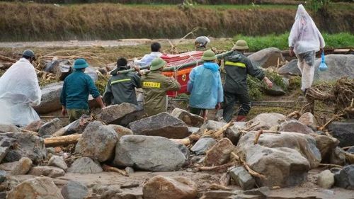 Lực lượng cứu hộ giúp người dân đưa người chết đi an táng.