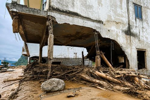  Một ngôi nhà ở xã Mường Than bị nước lũ làm hư hại một phần tầng trệt và móng, lộ ra bộ khung, ngày 18-7. Ảnh: HỒNG NGÂN 