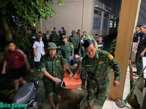 Một người dân không thể đi lại, được bộ đội dùng cáng di dời ra khỏi khu vực có nguy cơ bị sạt lở. Ảnh: Văn Hợi