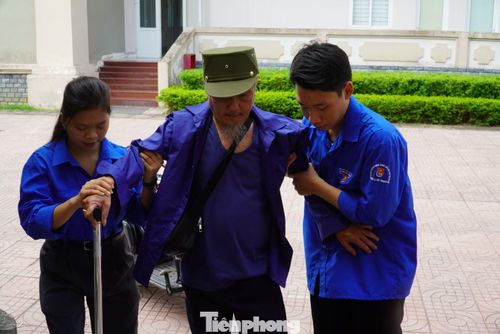 Đoàn viên thanh niên dìu thương binh đến khu vực khám sức khỏe trong chương trình tri ân.