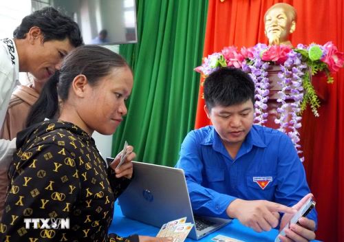 Người dân tộc Cor ở thôn Trà Thanh, xã Thanh Bồng (Quảng Ngãi) được thành viên Tổ công tác lưu động hỗ trợ thực hiện thủ tục hành chính. (Ảnh: Lê Phước Ngọc/TTXVN)