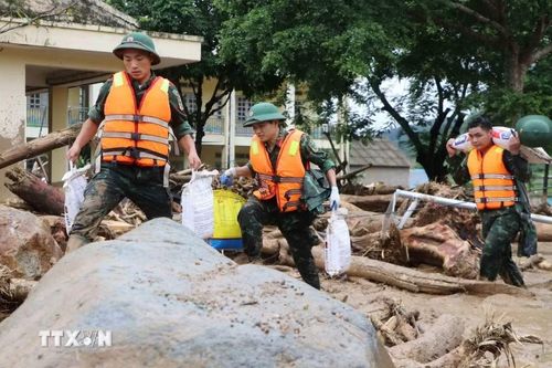 Các lực lượng cứu hộ của tỉnh Lai Châu giúp người dân Mường Than di dời tài sản đến nơi an toàn. (Ảnh: Nguyễn Oanh/TTXVN)