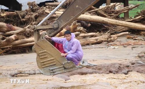 Hỗ trợ người dân di chuyển đến nơi an toàn. (Ảnh: Nguyễn Oanh/TTXVN)