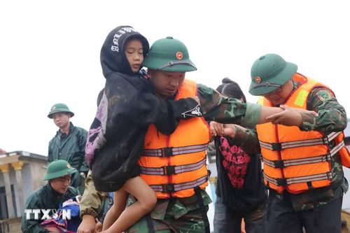 Các lực lượng cứu hộ giúp người dân di chuyển đến nơi an toàn. (Ảnh: Nguyễn Oanh/TTXVN)