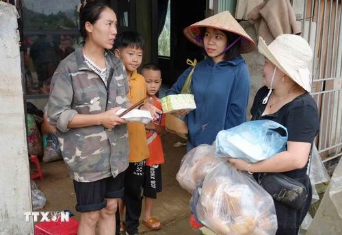 Tiếp tế thực phẩm cho những gia đình bị lũ cuốn trôi. (Ảnh: Nguyễn Oanh/TTXVN)