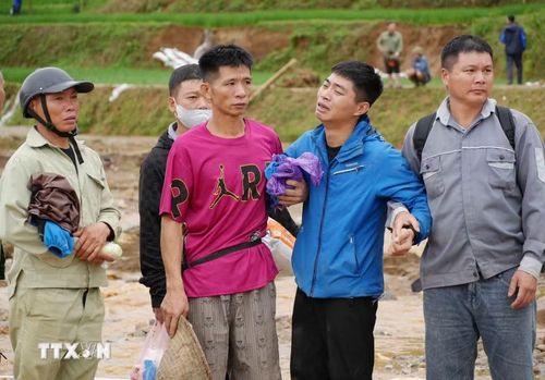 Nỗi đau của nhưng gia đình khi có nguời mất trong cơn lũ. (Ảnh: Nguyễn Oanh/TTXVN)