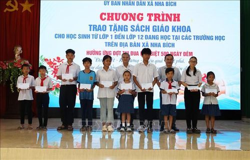 Lãnh đạo thành phố Đồng Nai và lãnh đạo xã Nha Bích tặng quà cho học sinh có hoàn cảnh khó khăn.