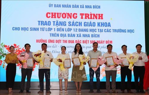 Đại diện lãnh đạo UBND xã Nha Bích tặng hoa cho các đơn vị tài trợ.