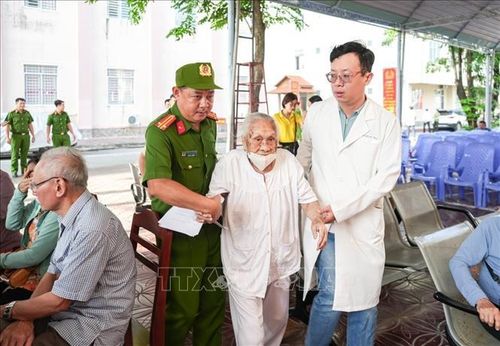 Các thân nhân liệt sĩ tuổi cao, sức yếu được cán bộ, chiến sĩ Công an thành phố tận tình hỗ trợ đưa đón. Ảnh: TTXVN phát