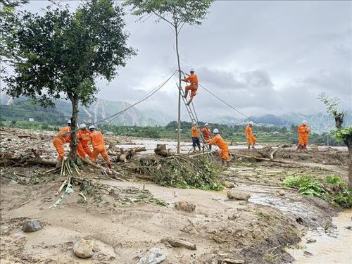 Cán bộ ngành Điện Lai Châu tích cực khôi phục dòng điện để sớm cung cấp điện ổn định phục vụ sinh hoạt, sản xuất của người dân vùng lũ. Ảnh: TTXVN phát