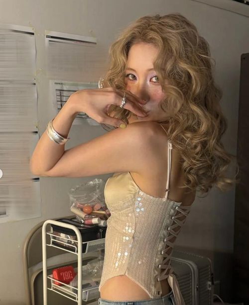Sunmi chụp ảnh selfie trước gương trong phòng chờ, tiếp tục gây chú ý với phong cách thời trang táo bạo. 