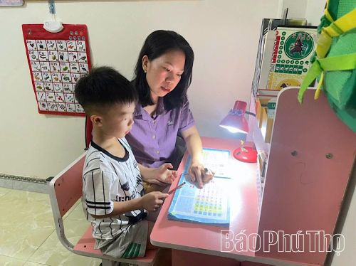 Chị Nguyễn Thị Thúy Hà, thôn Thống Nhất, xã Yên Lập hướng dẫn con làm quen với chữ cái.