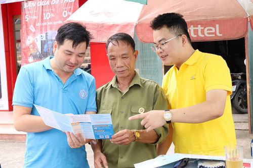 Cán bộ Bưu điện và Bảo hiểm xã hội tuyên truyền, tư vấn chính sách BHXH, BHYT cho người dân.