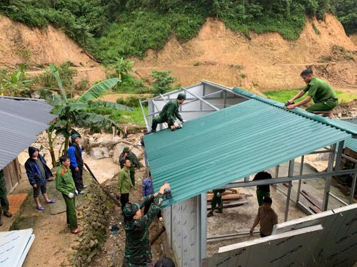 Cán bộ, chiến sĩ Đồn Biên phòng Pa Ủ hỗ trợ nhân dân khắc phục hậu quả thiên tai.
