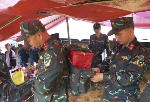 Thượng tá Lê Đình Hải cẩn thận buộc lại ba-lô để Trung tá Đào Xuân Trường đưa hài cốt liệt sĩ từ trên đỉnh đèo Pha Đin xuống.