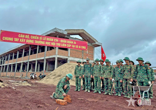 Cán bộ Lữ đoàn Pháo phòng không 234 (Quân đoàn 34) hướng dẫn lực lượng thợ xây hỗ trợ thi công trường nội trú xã Ia Chia (Gia Lai). 