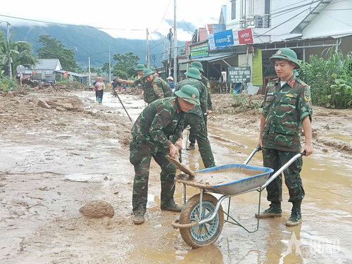 Cán bộ, chiến sĩ Trung đoàn 880, Bộ CHQS tỉnh Lai Châu phối hợp san gạt bùn đất, vệ sinh môi trường tại vùng lũ xã Mường Than, tỉnh Lai Châu.