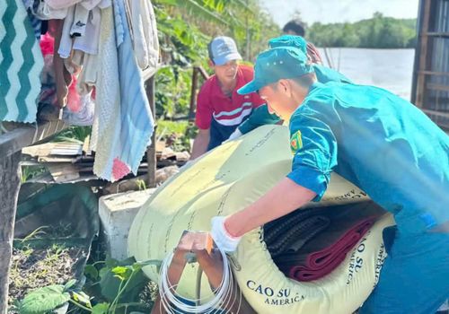 Lực lượng chức năng hỗ trợ người dân di dời đồ đạc ra khỏi khu vực nguy hiểm do sạt lở