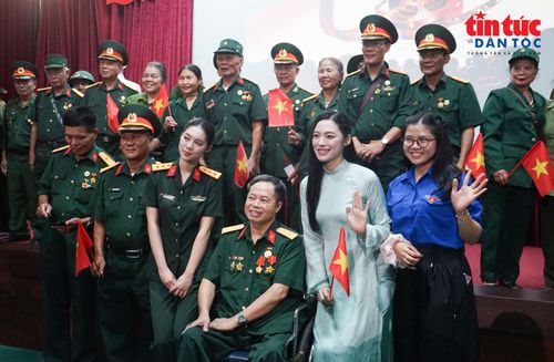 Bạn trẻ Nguyễn Thị Vân Nhi (áo dài xanh) chụp ảnh kỷ niệm cùng các các bác cựu chiến binh tại chương trình.