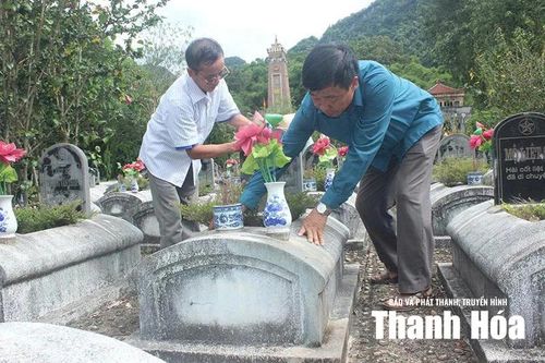 Ông Phạm Văn Nguyễn (bên phải) cùng ông Lê Văn Xế (bên trái) chăm sóc các phần mộ liệt sĩ tại Nghĩa trang liệt sĩ quốc tế Đồng Tâm (xã Thiết Ống).