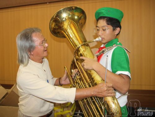 Em Vũ Nhật Minh cùng thầy ôn lại các thao tác biểu diễn kèn Tuba trước khi lên sân khấu.