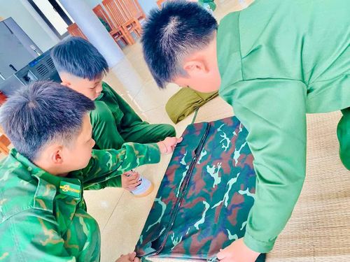 Dưới sự hướng dẫn của cán bộ huấn luyện, các học viên làm quen với nếp sống chính quy, bắt đầu từ việc gấp chăn màn gọn gàng, vuông vức.