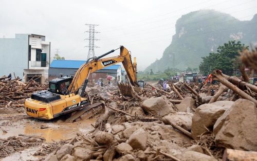 Các phương tiện máy móc tập trung san gạt cây cối, đất đá góp phần thông đường tạm thời cho nhân dân đi lại. Ảnh: Quý Trung - TTXVN