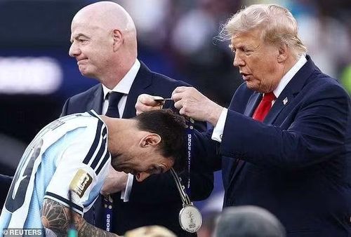 Bên kia chiến tuyến, Lionel Messi cúi đầu để Tổng thống Donald Trump trao Huy chương Bạc, trong khi Chủ tịch FIFA Gianni Infantino đứng bên cạnh. Khoảnh khắc lặng lẽ đối lập hoàn toàn với lễ hội của Tây Ban Nha. Ảnh: Reuters.