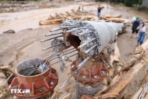 Cột điện bị gãy đổ sau khi cơn lũ dữ đi qua. (Ảnh: Quý Trung/TTXVN)