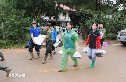 Các lực lượng công an, thanh niên tình nguyện đưa những suất cơm tình nghĩa đến với nhân dân và các lực lượng đang hỗ trợ nhân dân tại xã Mường Than. (Ảnh: Quý Trung/TTXVN)