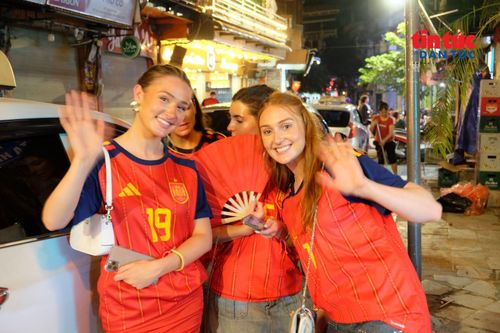 Nhóm nữ cổ động viên rạng rỡ ăn mừng chiến thắng trong trang phục của đội tuyển Tây Ban Nha.