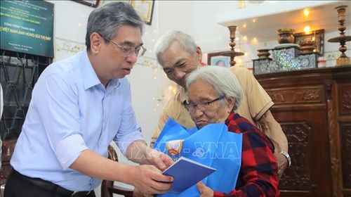 Thay mặt lãnh đạo Thành ủy, ông Nguyễn Phước Lộc trao tặng quà cho Mẹ Việt Nam Anh hùng Bùi Thị Đay. Ảnh: Huỳnh Sơn/TTXVN