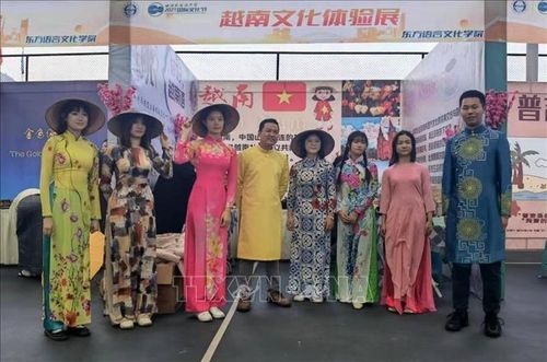 Phó Giáo sư, Tiến sĩ Nguyễn Xuân Diện (thứ 4, từ trái qua) tham gia hoạt động quảng bá áo dài Việt Nam tại Trùng Khánh. Ảnh: TTXVN phát