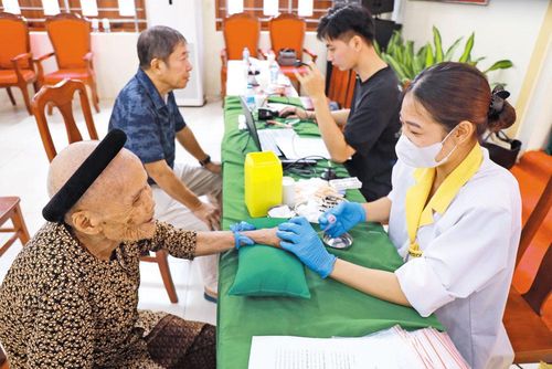  Lực lượng chức năng thu nhận mẫu ADN của thân nhân liệt sĩ ở phường Bắc Giang. Ảnh: Tuyết Mai. 
