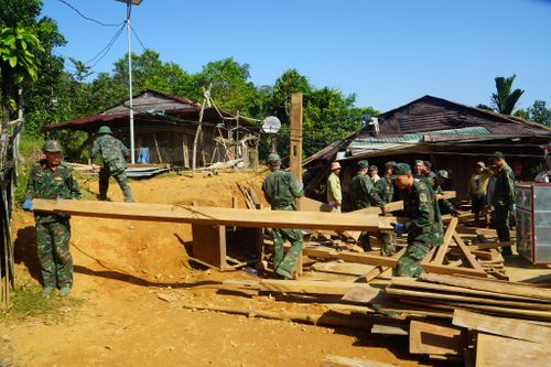 Hơn 200 cán bộ, chiến sĩ Sư đoàn 315 (Quân khu 5) giúp đồng bào tháo dỡ, vận chuyển nhà đến nơi ở mới. Ảnh: TRUNG LÊ