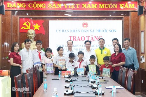 Lãnh đạo xã Phước Sơn và doanh nghiệp tặng sách giáo khoa cho thầy và trò các trường học trên địa bàn. Ảnh: Quang Minh
