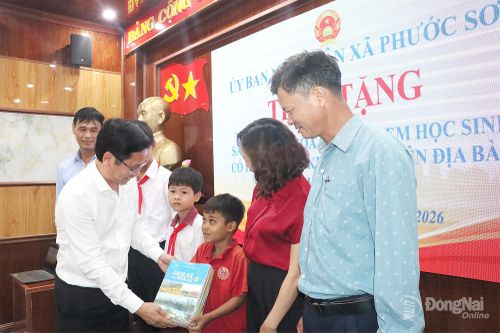 Chủ tịch UBND xã Phước Sơn Trần Ngọc Công tặng sách giáo khoa cho học sinh khó khăn trên địa bàn. Ảnh: Quang Minh