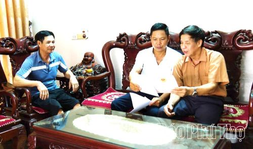 Cán bộ thôn Phúc Lập, xã Vĩnh Tường tuyên truyền, hướng dẫn ông Hoàng Trung Ca (bên phải) kê khai, cập nhật thông tin đất đai phục vụ công tác chuẩn hóa dữ liệu.