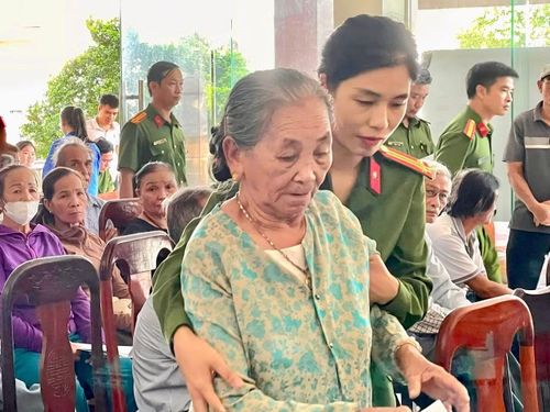 Một nữ cán bộ Công an phường Nam Đông Hà giúp đỡ một bà cụ làm thủ tục lấy mẫu ADN.
